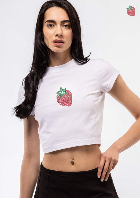 Woman wearing a white t-shirt with a strawberry design on a plain background