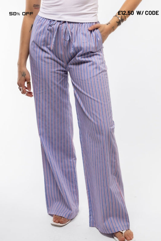 Woman wearing blue striped pants on a white background