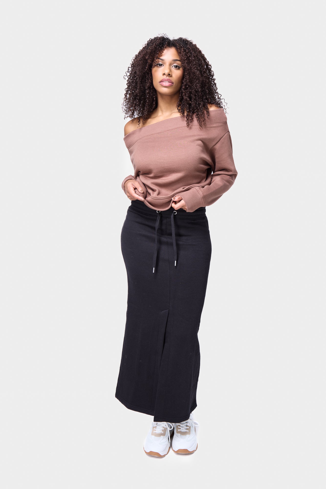 Women’s black midi skirt featuring a front slit and comfortable elastic band, perfect for everyday streetwear.
