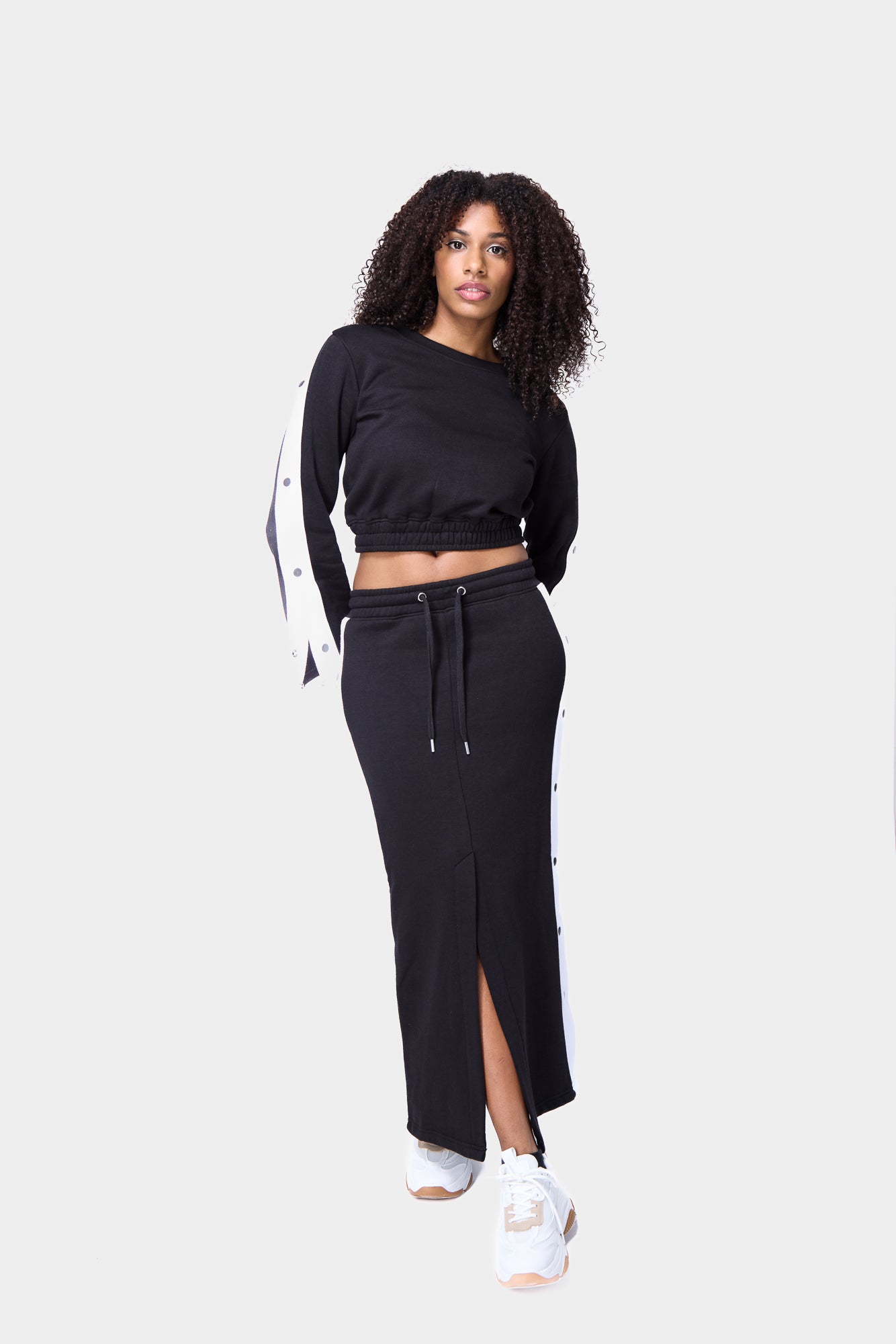 Black snap-button midi skirt, perfect for a modern sportswear-inspired look.