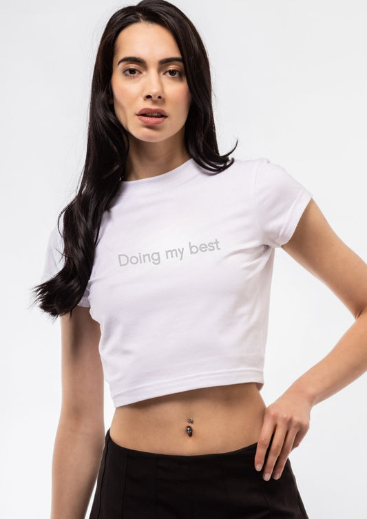 Woman wearing a white t-shirt with 'Doing my best' text on a plain background