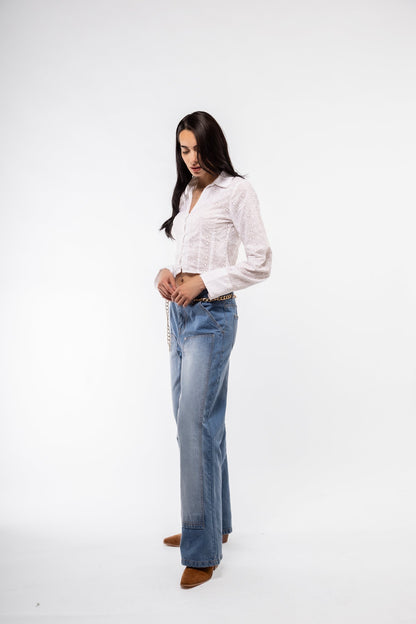 Side profile of white broderie long-sleeve cropped shirt – feminine silhouette

