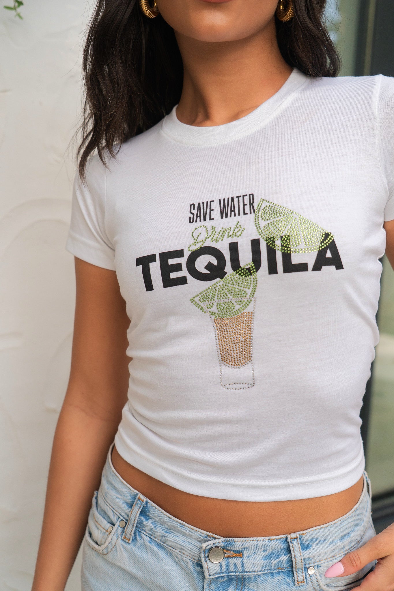 Person wearing a white t-shirt with 'Save Water, Drink Tequila' text and graphic.