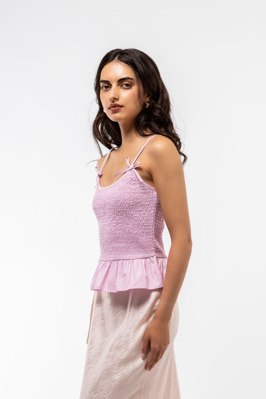 side profile of model wearing the shirring pink bow top 