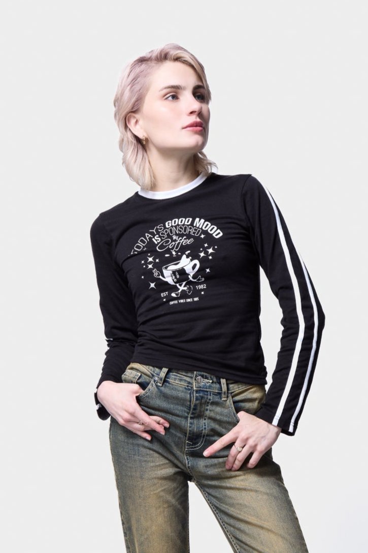 Model wearing Silkroad Daughters black graphic tee with faded high-waisted jeans and cowboy boots