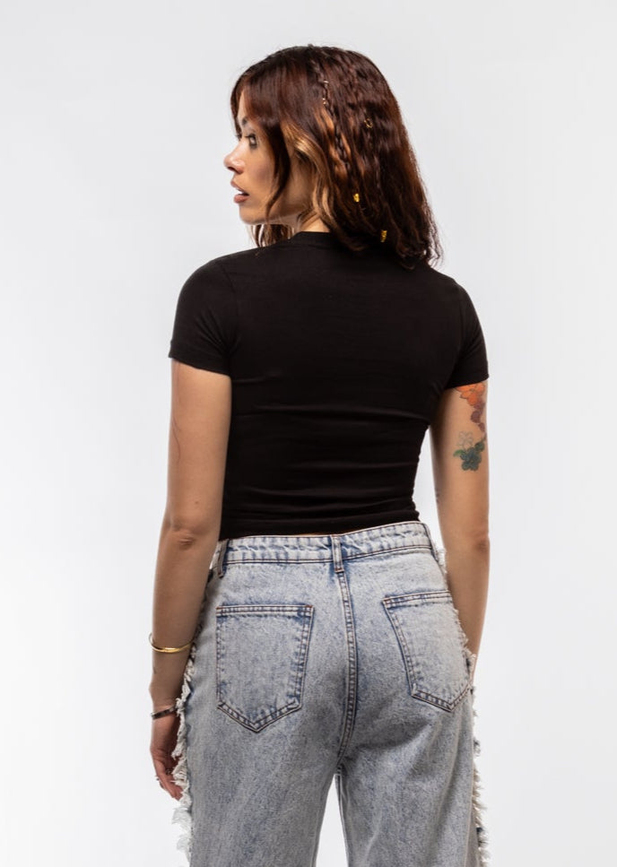 Model wearing a black t-shirt and light blue jeans against a white background