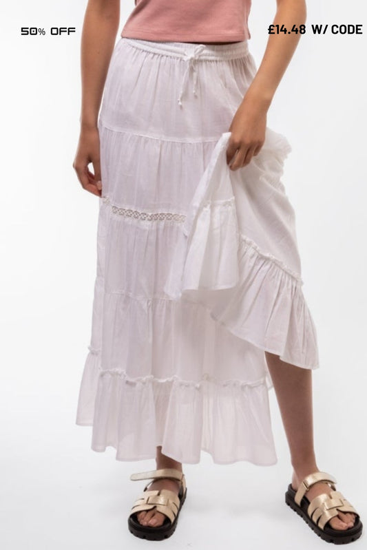 White tiered skirt worn by a person on a white background with promotional text.