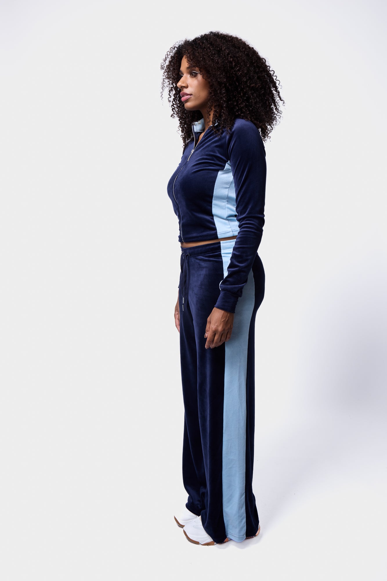 Model in contrast panel velour tracksuit in navy and light blue