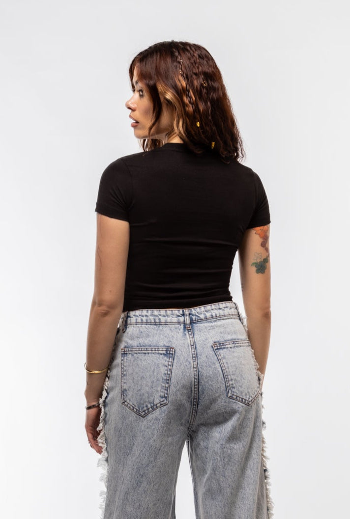 Person wearing high-waisted gray jeans and a black top on a white background