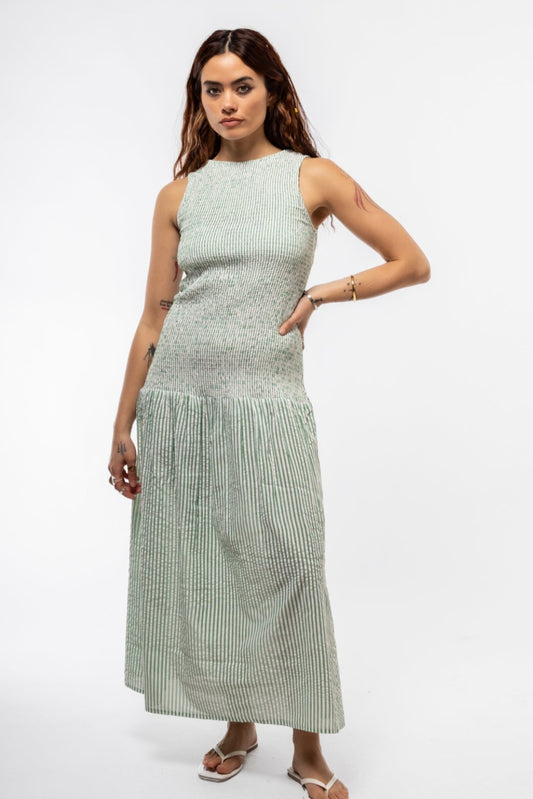 Woman wearing a light green sleeveless dress on a white background